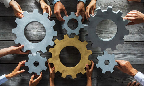 Business people joining gears